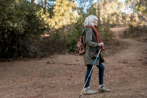 Femme plus âgée bénéficiant d'une randonnée dans la nature