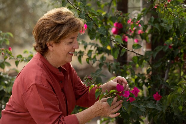 Femme plus âgée profitant de la nature dans son jardin de campagne