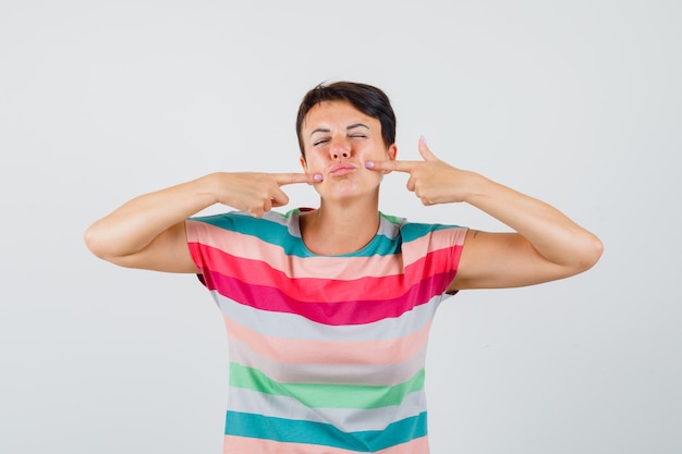 Femme pointant sur sa bouche en vue de face de t-shirt rayé.