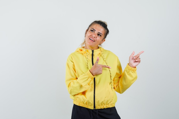 Femme pointant vers le coin supérieur droit en costume de sport et à la recherche de rêve. vue de face.