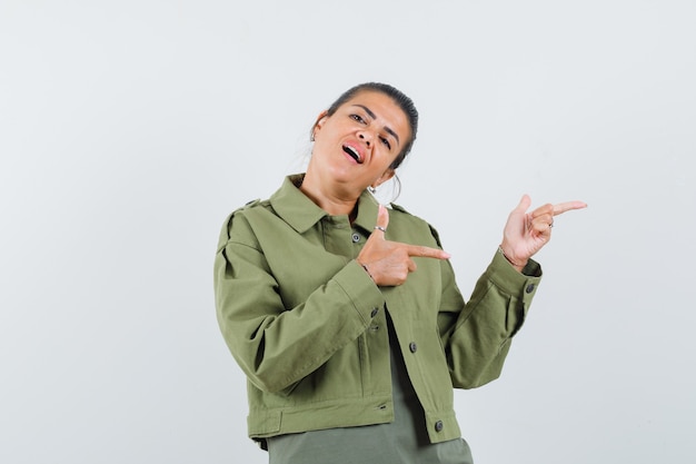 femme pointant vers le côté droit en veste, t-shirt et à la recherche de confiance.