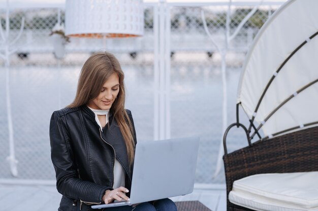Femme avec port arrière-plan avec un ordinateur portable sur ses jambes