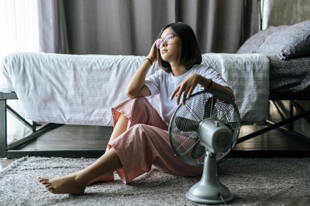 La femme portait une chemise blanche et une main, placée sur l'éventail de la table et regarda.