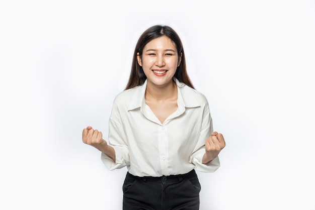 Photo gratuite la femme portait une chemise blanche et un pantalon sombre et a fait une pose amusante