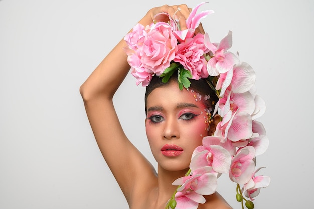 La Femme Portait Du Maquillage Rose Et Joliment Décoré Les Fleurs Isolées Sur Blanc