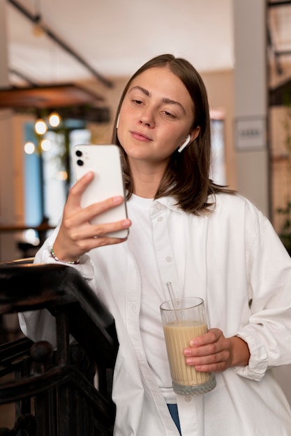 Femme portant des écouteurs en choisissant une chanson sur son téléphone