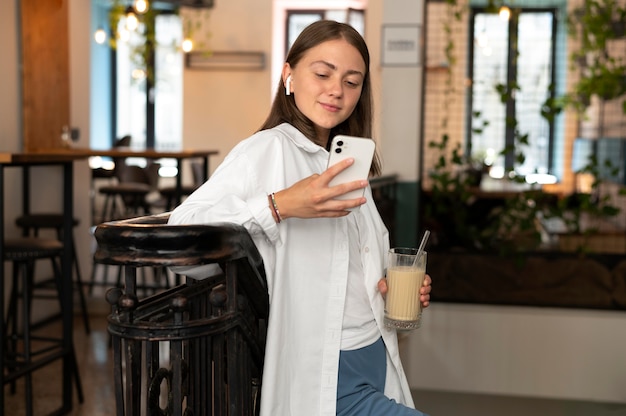 Femme portant des écouteurs en choisissant une chanson sur son téléphone