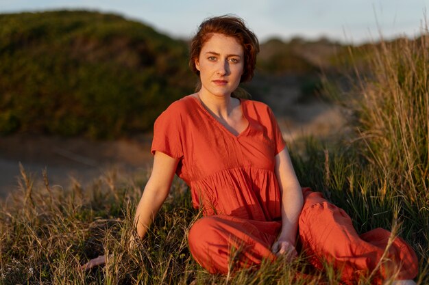 Femme portant sur l'herbe plein coup