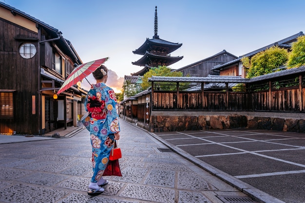 Femme portant un kimono traditionnel japonais avec parapluie à la pagode Yasaka et la rue Sannen Zaka à Kyoto, au Japon.