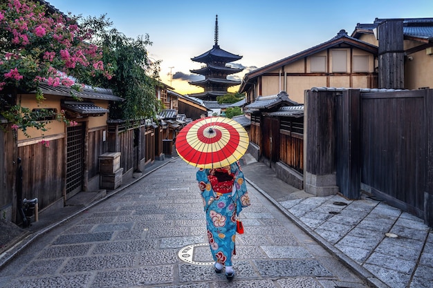 Photo gratuite femme portant un kimono traditionnel japonais avec parapluie à la pagode yasaka et la rue sannen zaka à kyoto, au japon.