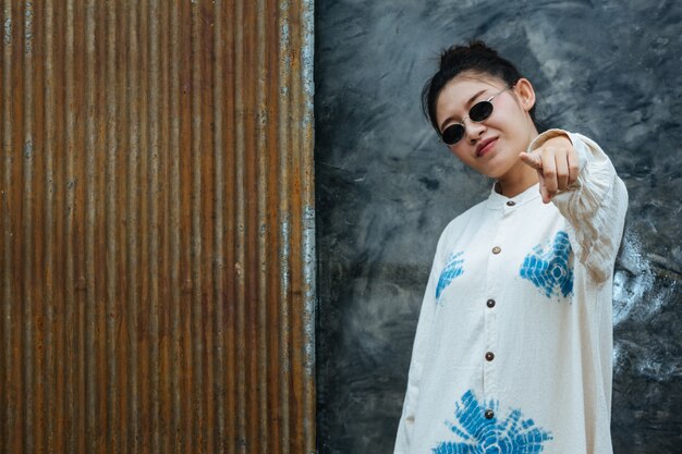 Une femme portant des lunettes indique que le ciment est gris et rouille.