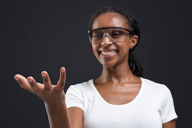 Femme portant des lunettes transparentes montrant un objet invisible