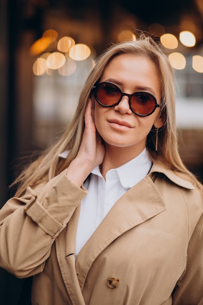 Femme portant un manteau beige et marchant dans la rue à Noël