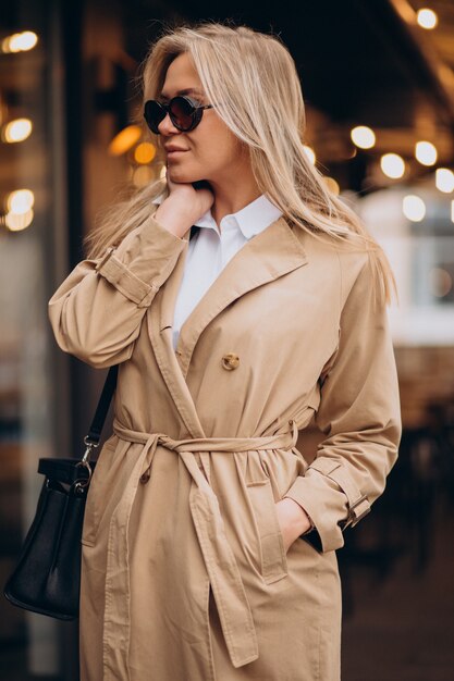 Femme portant un manteau beige et marchant dans la rue à Noël