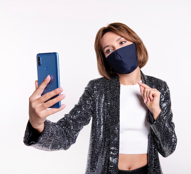 Femme portant un masque facial prenant un selfie