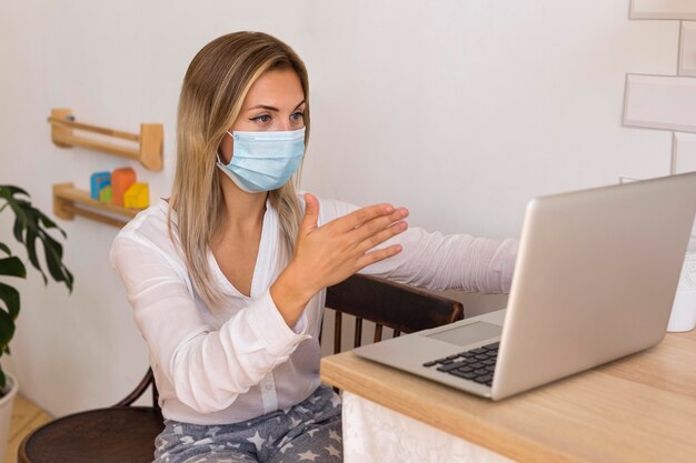 Femme portant un masque à la maison