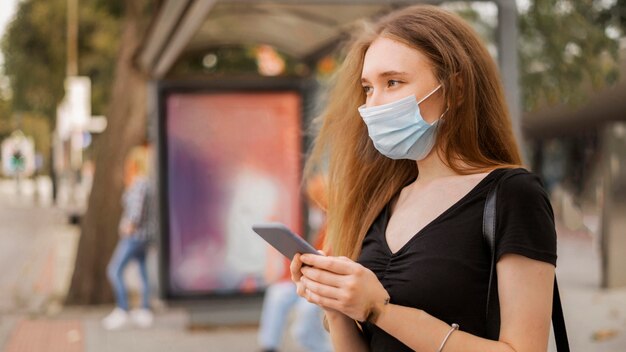 Femme portant un masque médical à l'extérieur