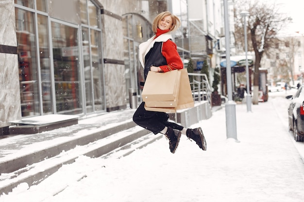 Femme portant des sacs à provisions dans un centre commercial en plein air