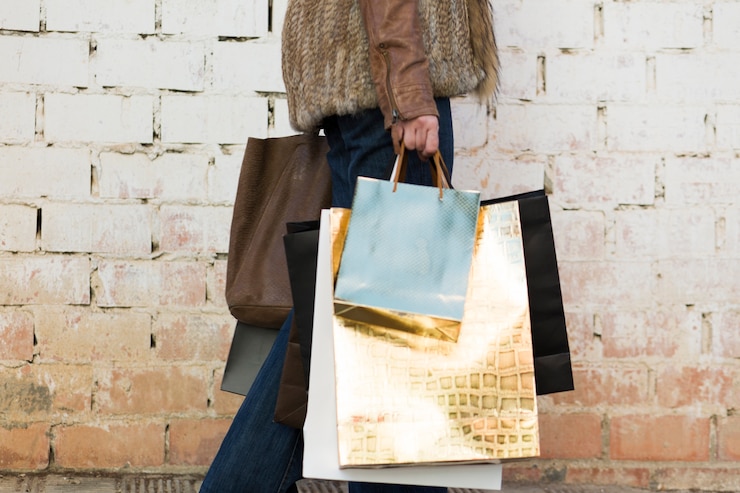 Photo gratuit femme portant des sacs à provisions près du mur