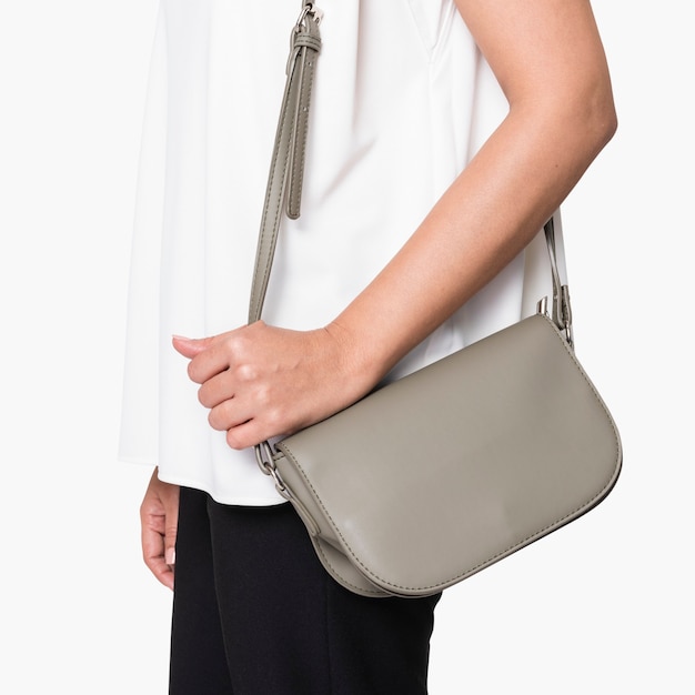 Femme portant son sac bandoulière en cuir gris