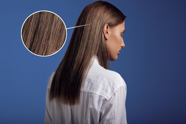 La femme porte une chemise blanche à l'arrière montrant des cheveux raides idéaux