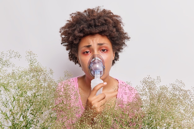 la femme porte un masque à oxygène fait l'inhalation a les yeux rouges souffre d'allergie allergique au pollen isolé sur blanc