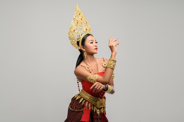 femme porte des vêtements thaïlandais. La main droite est placée sur la main gauche.