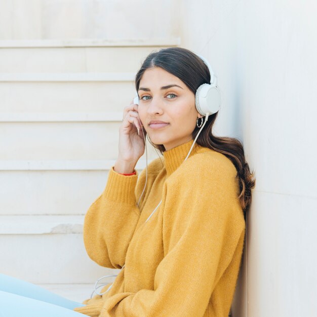 femme, porter, écouteurs, regarder appareil-photo