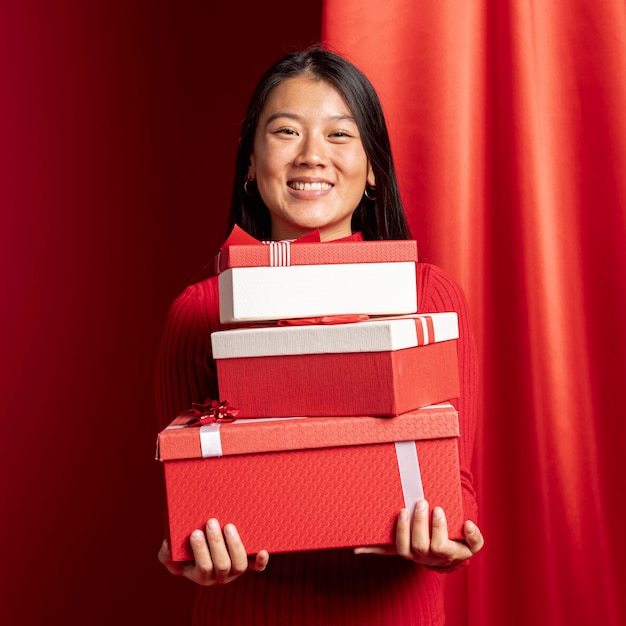 Femme posant avec des coffrets cadeaux pour le nouvel an chinois