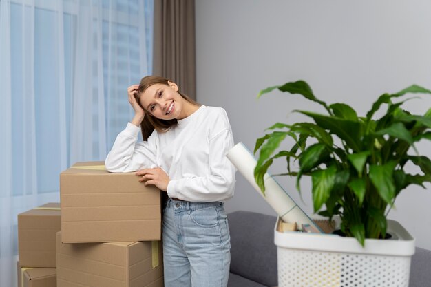 Femme posant à côté de boîtes d'effets personnels