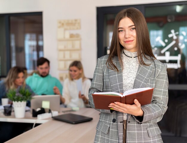 Femme posant à côté de ses collègues