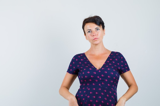 Femme posant debout en robe et à la recherche sensible.