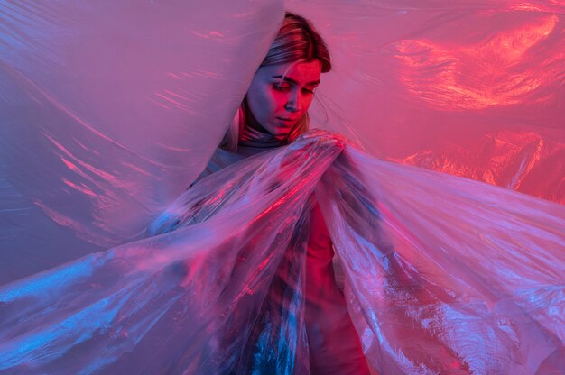 Femme posant avec une feuille de plastique