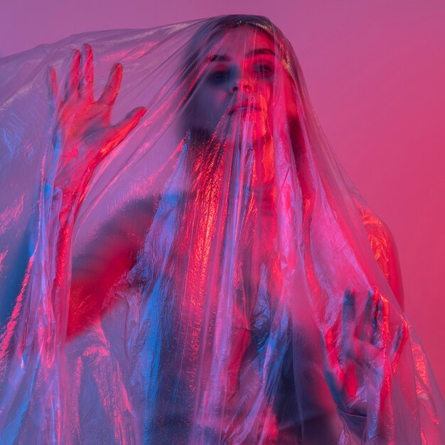 Femme posant avec une feuille de plastique