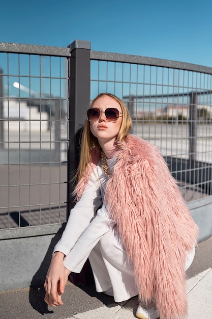 Photo gratuite femme posant avec des lunettes de soleil plein coup