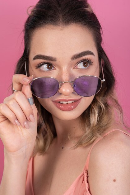 Femme posant avec des lunettes violettes