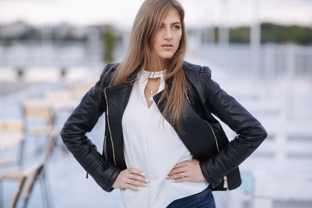 Femme posant avec les mains sur les hanches dans un restaurant sur un port