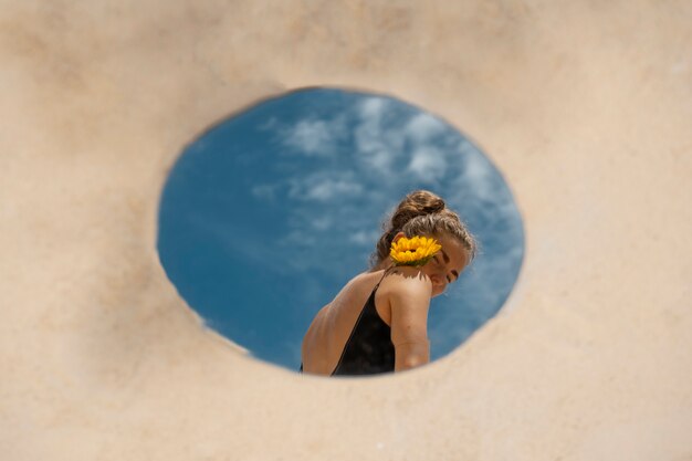 Femme posant avec miroir rond et fleur