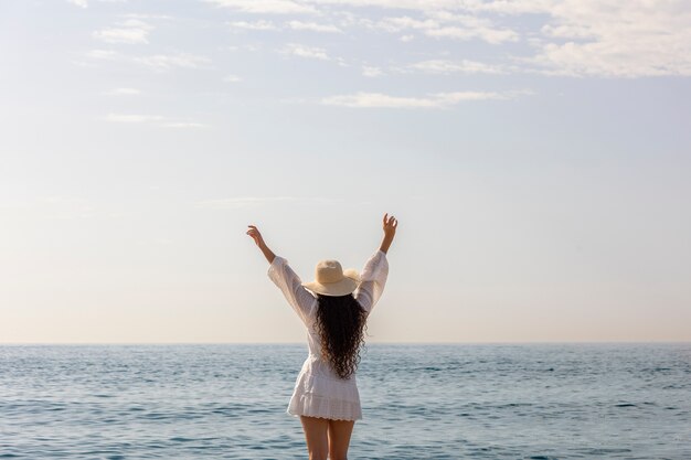 Femme posant sur la plage vue arrière