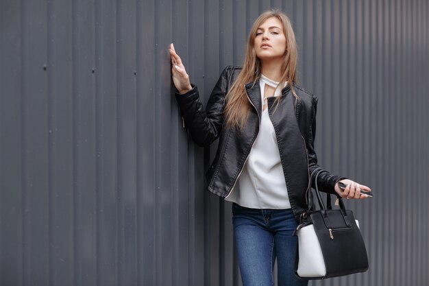 Femme posant avec un sac noir et blanc