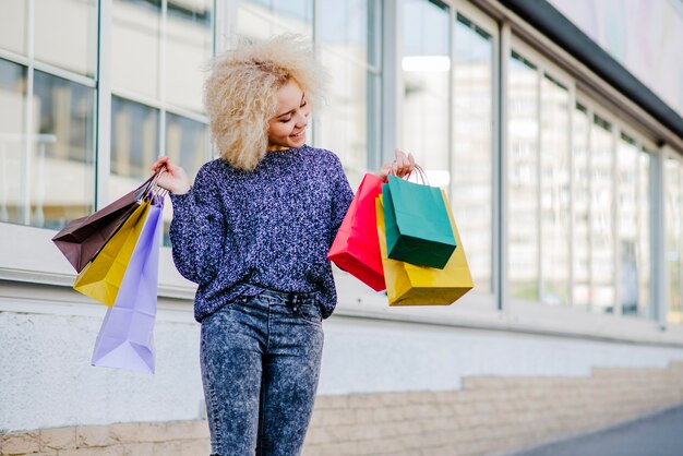 Femme posant avec des sacs à provisions