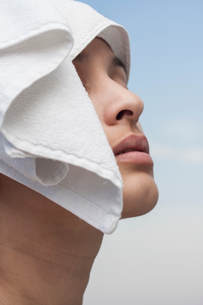 Femme posant avec une serviette blanche sur la tête