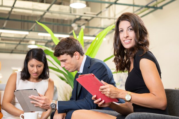 Femme posant avec tablette au bureau