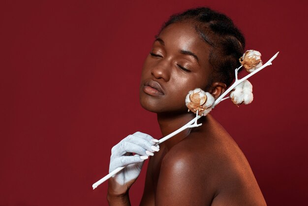 Femme posant avec vue de côté de fleur de coton