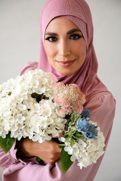 Femme posant avec vue de face de fleurs