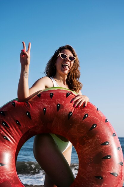 Femme posant avec vue latérale sur la bouée de sauvetage