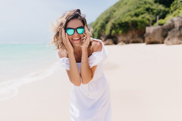 Femme positive caucasienne s'amuser pendant le week-end d'été à la station. Bonne humeur jeune femme exprimant le bonheur