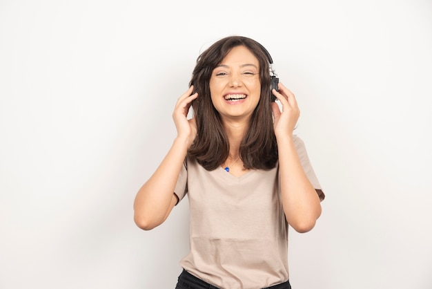 Une femme positive écoute de la musique dans des écouteurs et bénéficie d'un son agréable.