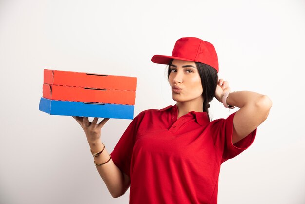 Femme positive avec pizza posant sur fond blanc.