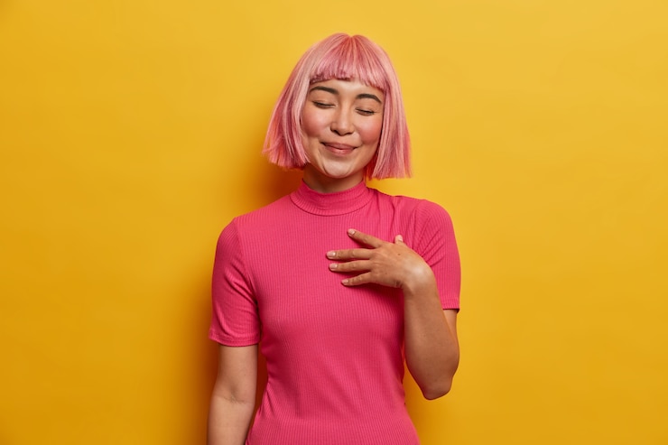 Photo gratuit une femme positive à la recherche agréable aime une conversation réconfortante avec un bon ami, garde la main sur le cœur, heureuse d'entendre un compliment, a une coiffure bob
